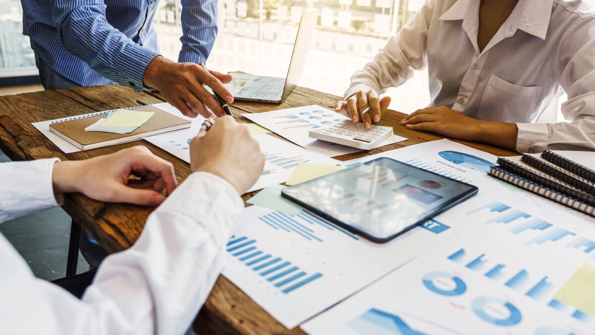 Hands of business team people meeting and discussing with business statistics paper charts.